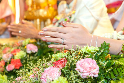 Cropped image of bride and groom praying during wedding ceremony