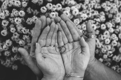 Close-up of couple hands holding rings in palm