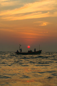 Silhouette boat in sea against sky during sunset