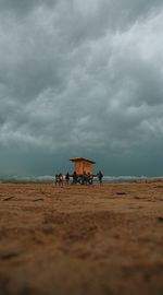 Scenic view of beach against cloudy sky