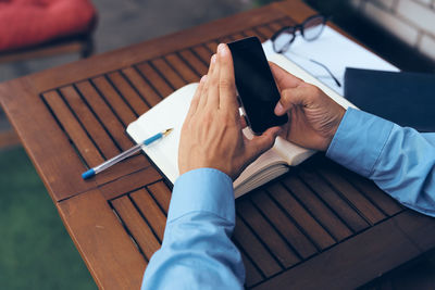 High angle view of man using mobile phone on table