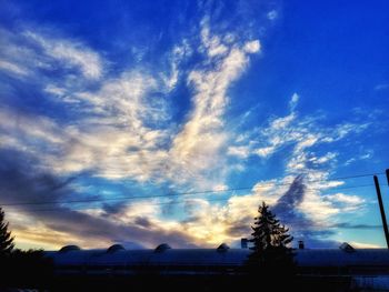 Low angle view of silhouette trees against sky