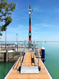 Lighthouse by lake against sky