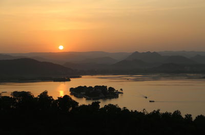 Scenic view of silhouette mountains against orange sky