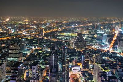 High angle view of illuminated cityscape against sky at night