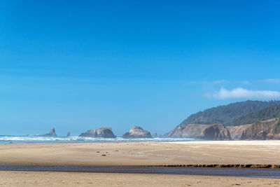 Scenic view of beach against blue sky