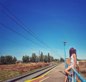 Man on road against clear blue sky