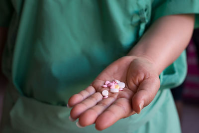 Midsection of patient holding pills