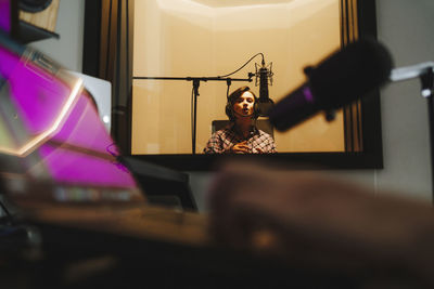 Singer recording music through microphone in studio