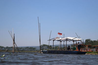 People on boat against clear sky
