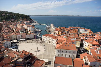 High angle view of townscape by sea against sky