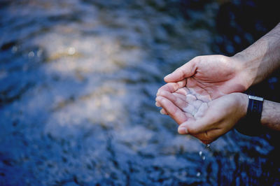 Close-up of hand touching water