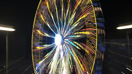 Low angle view of illuminated ferris wheel at night