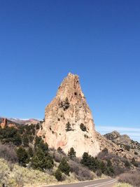 Rock formations on landscape against clear blue sky