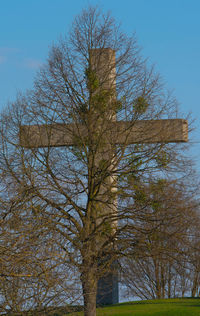 Low angle view of bare trees against clear blue sky