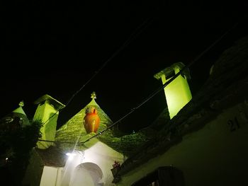 Low angle view of illuminated building against sky at night