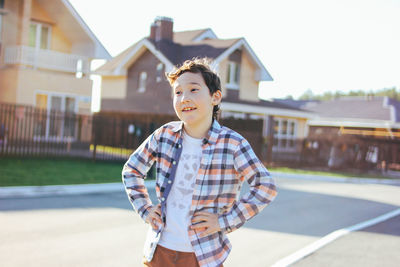 Full length of boy standing on house against building