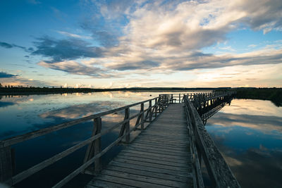 Pier over sea against sky during sunset