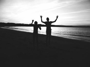 Silhouette men standing at beach