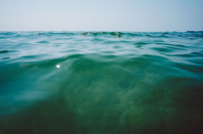 Surface level of sea against clear sky