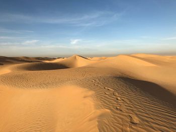 Sand dunes in desert against sky