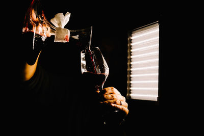 Man holding lit candles in dark room