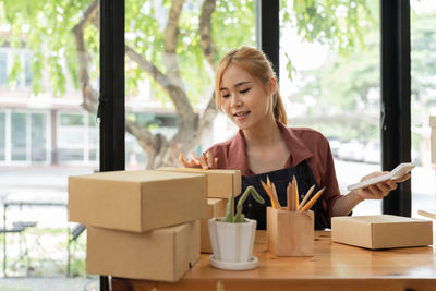 Happy woman with packages sitting at desk