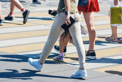 Low section of people walking on road