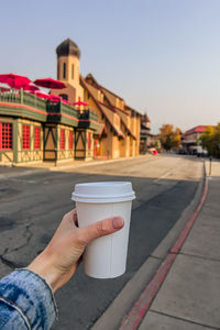 Cropped hand of woman holding disposable cup