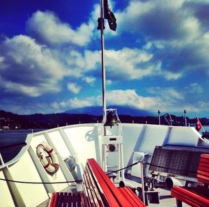 Boats in river against cloudy sky