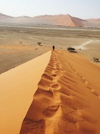 People standing on sand dune in desert