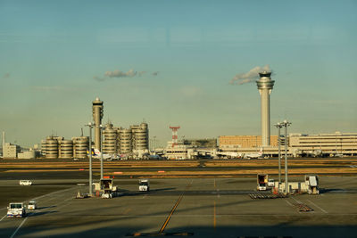 Vehicles on road and a aircraft  against sky in the airport