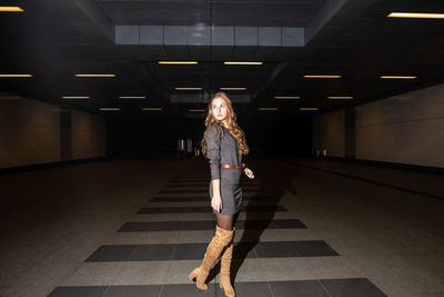 Full length of woman standing in underground walkway