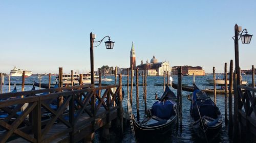 Boats moored on wooden post in city