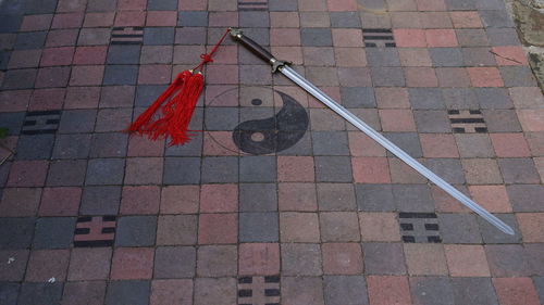 High angle view of sword by yin yang symbol on footpath