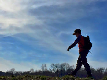 Low angle view of man with arms raised against sky