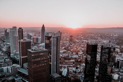 High angle view of city buildings against sky during sunset