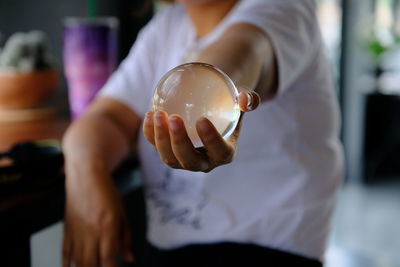 Close-up of hand holding crystal ball