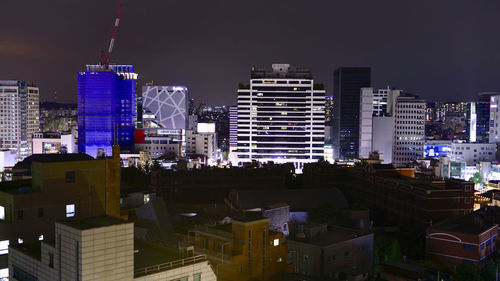 Modern buildings in city against sky at night