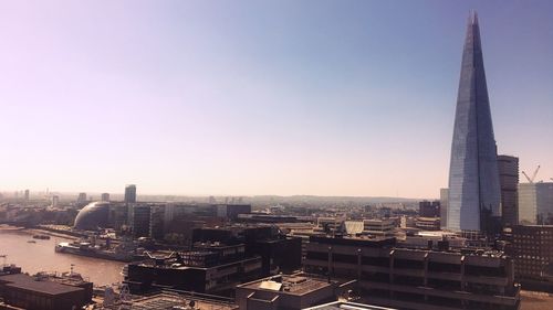 Aerial view of buildings in city against clear sky