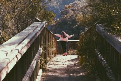 Woman standing on footbridge