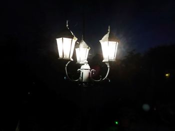 Low angle view of illuminated lamp at night