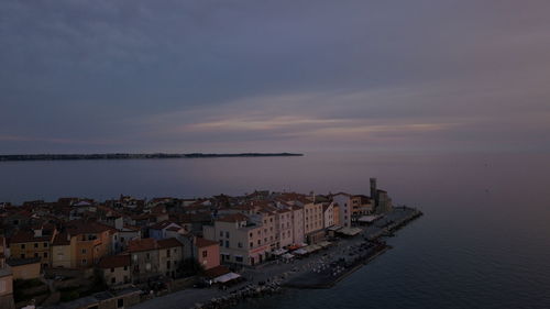 High angle view of townscape by sea against sky