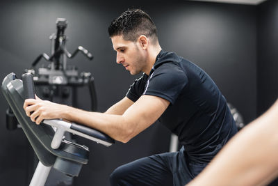 Young man at the gym on a bicycle