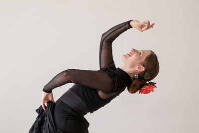 Side view of woman standing against white background