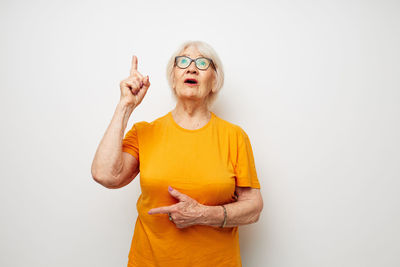 Portrait of young woman with arms crossed against white background