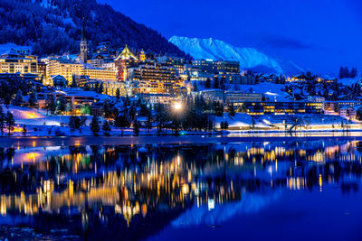 View of beautiful night lights of st. moritz in switzerland at night in winter, reflection from lake