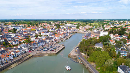 High angle view of town by sea against sky