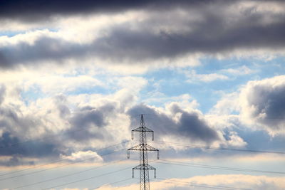 Low angle view of electricity pylon against sky