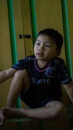 Portrait of cute boy sitting in gym